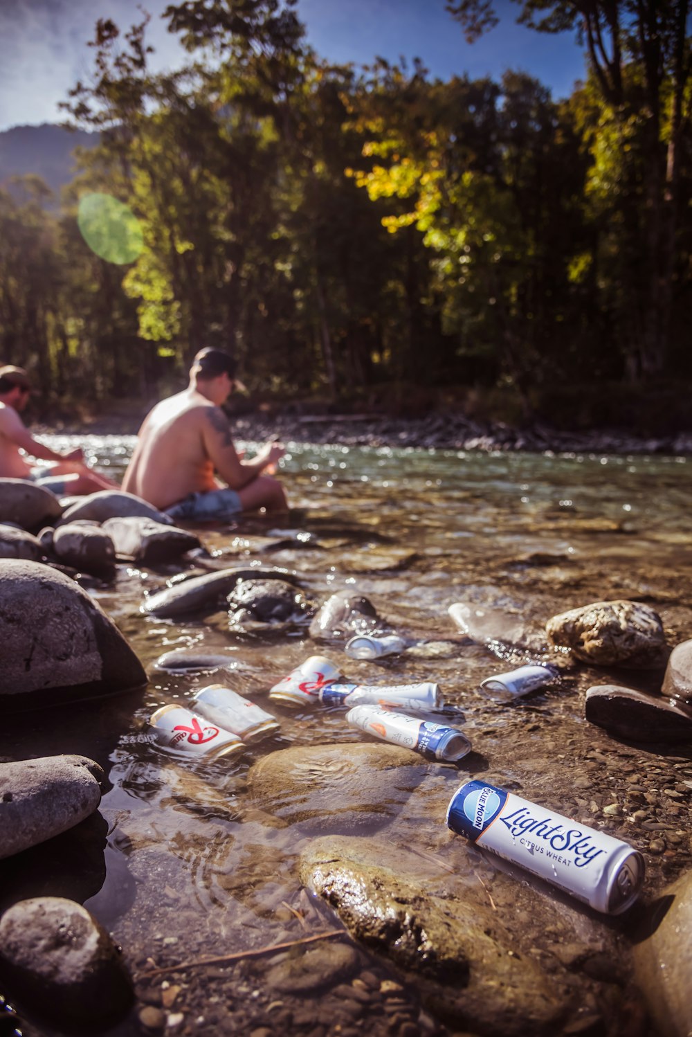 a group of people sitting on rocks next to a river