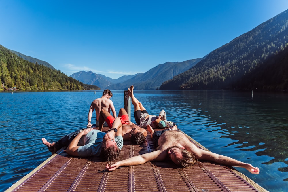 a group of people laying on top of a wooden dock