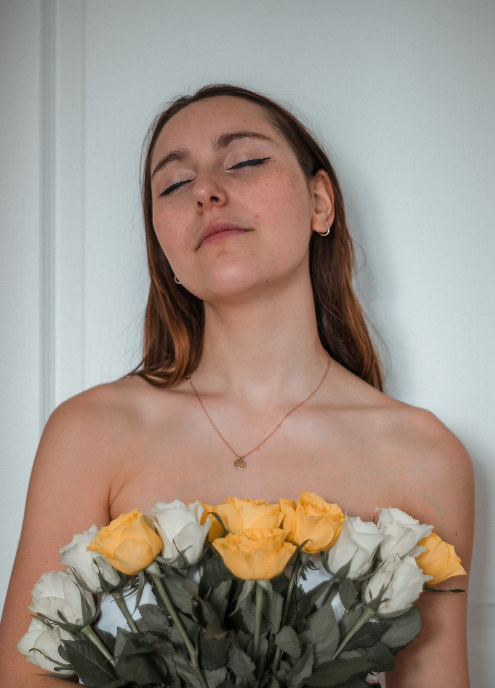 a woman with her eyes closed holding a bouquet of flowers