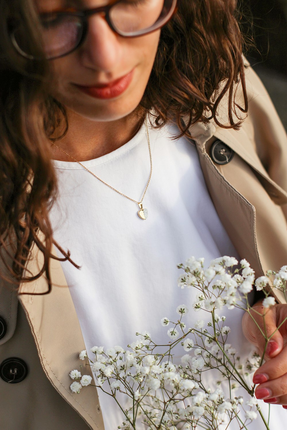 a woman holding a bunch of white flowers