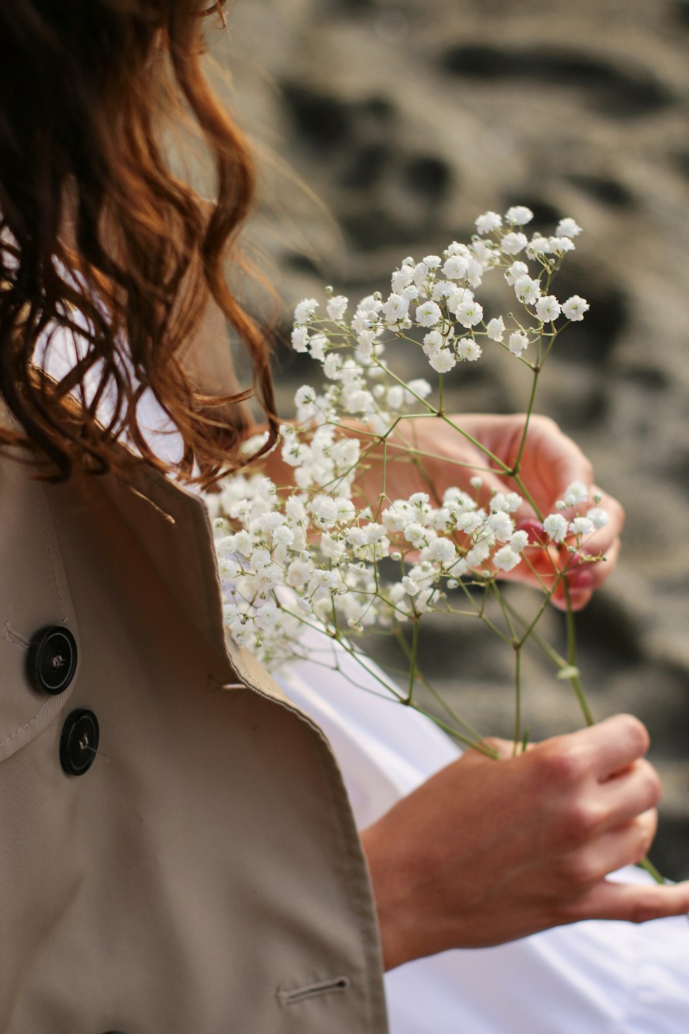a woman holding a bunch of white flowers