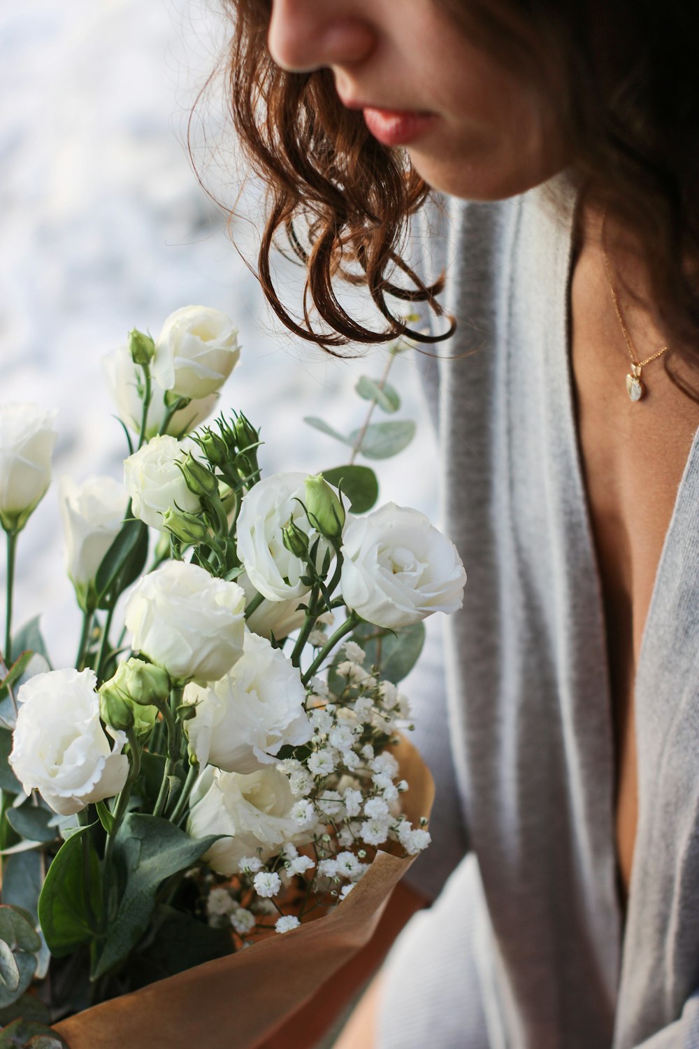 a woman holding a bouquet of white flowers