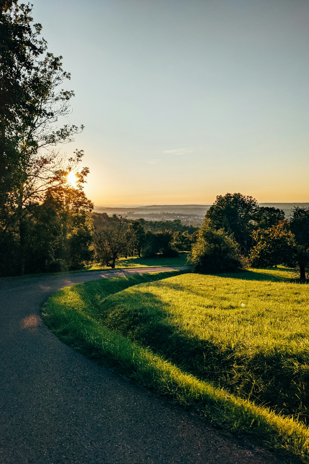 the sun is setting over a grassy field