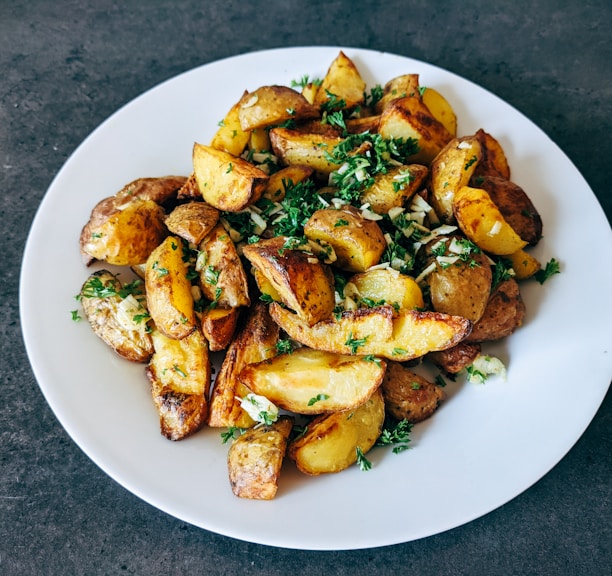 a white plate topped with potatoes and parsley