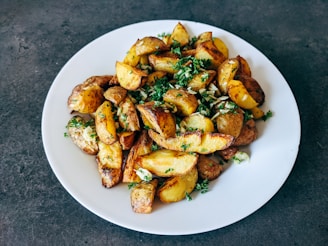 a white plate topped with potatoes and parsley