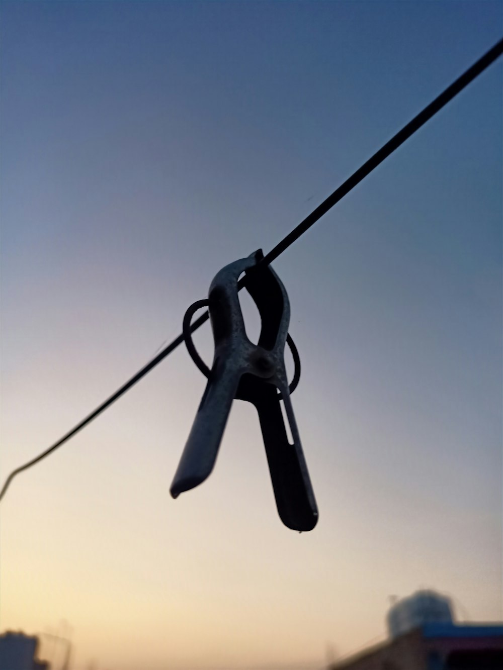 a pair of scissors hanging from a wire
