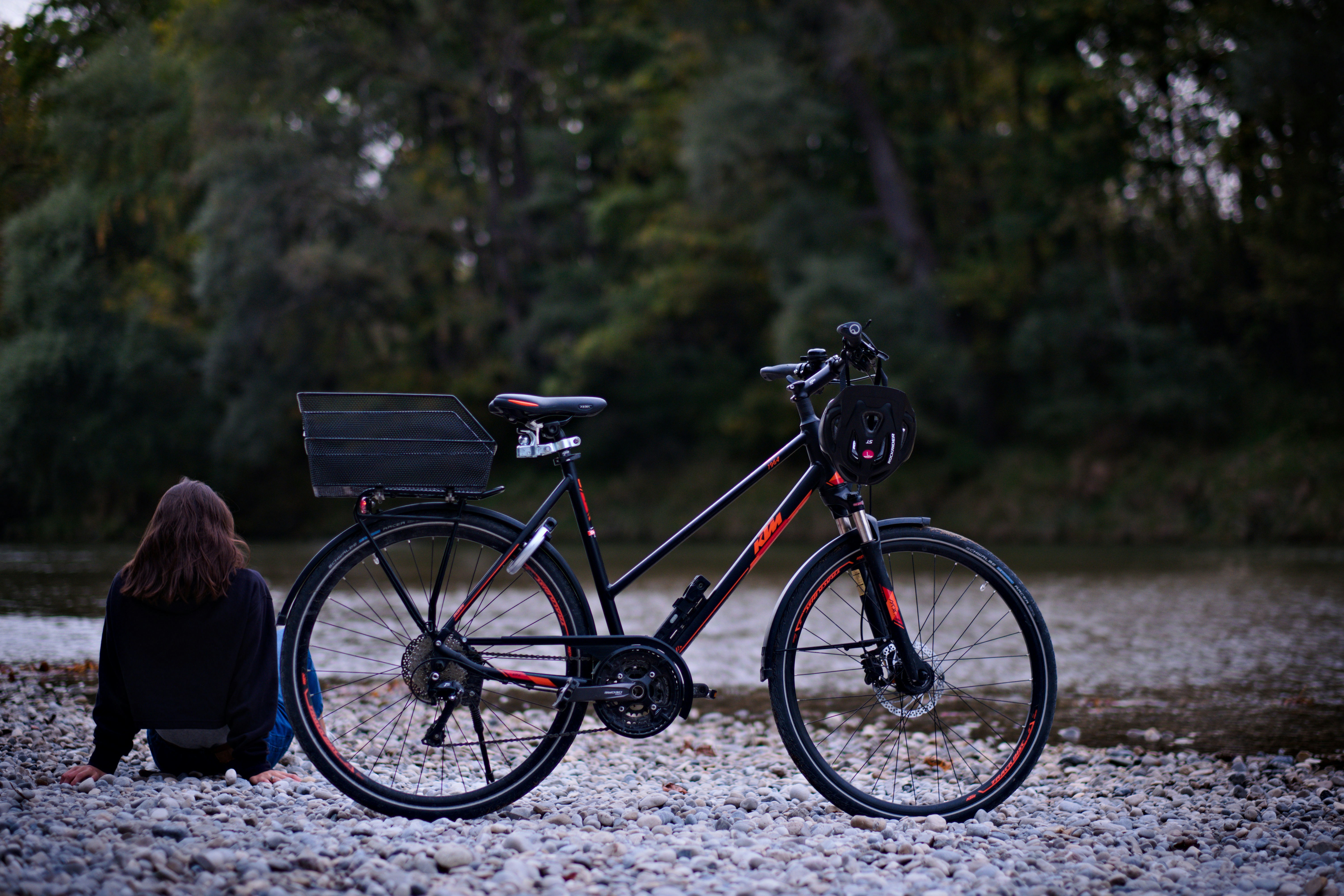 a woman sitting on the ground next to a bike
