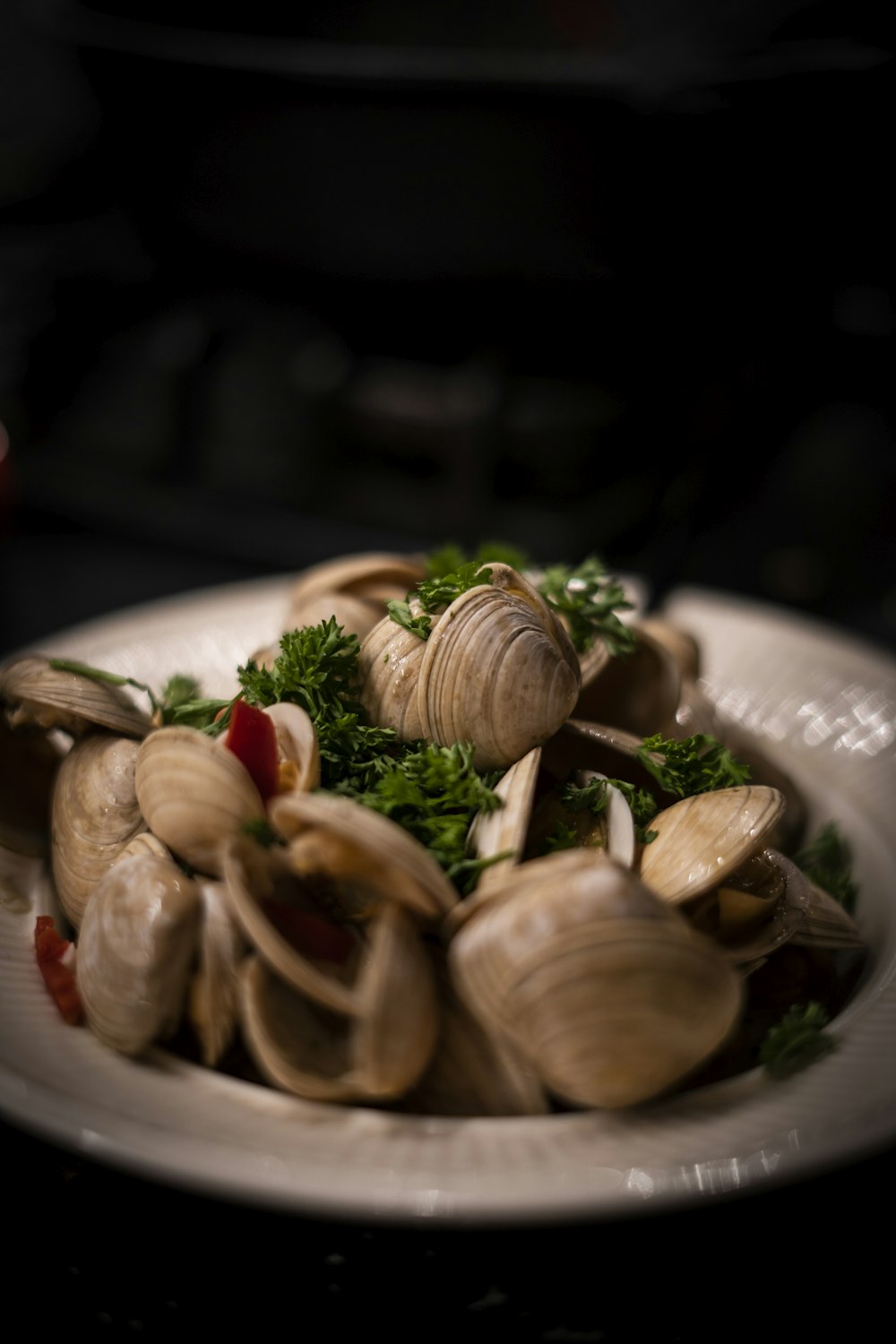 a white plate topped with clams and parsley