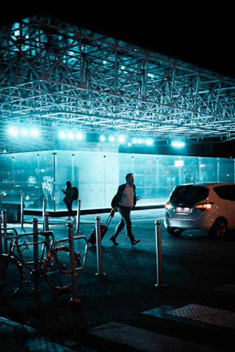 a couple of people walking down a street at night