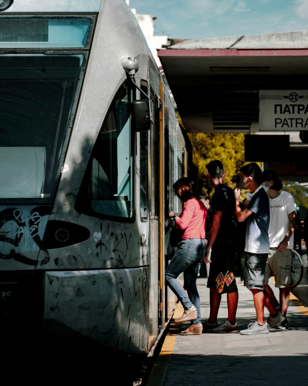 a group of people standing next to a train