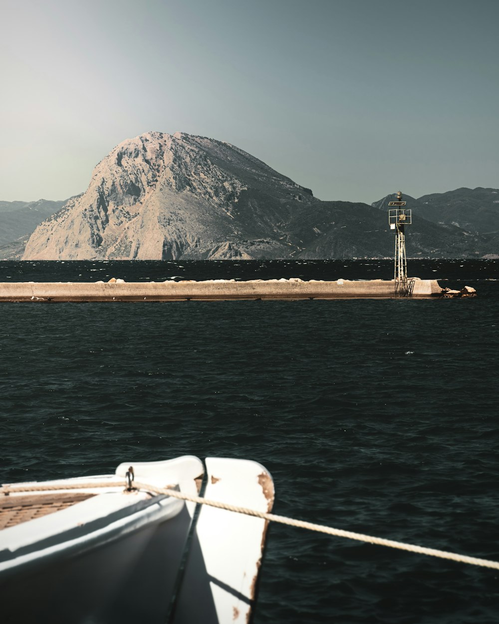 a boat in the water with a mountain in the background