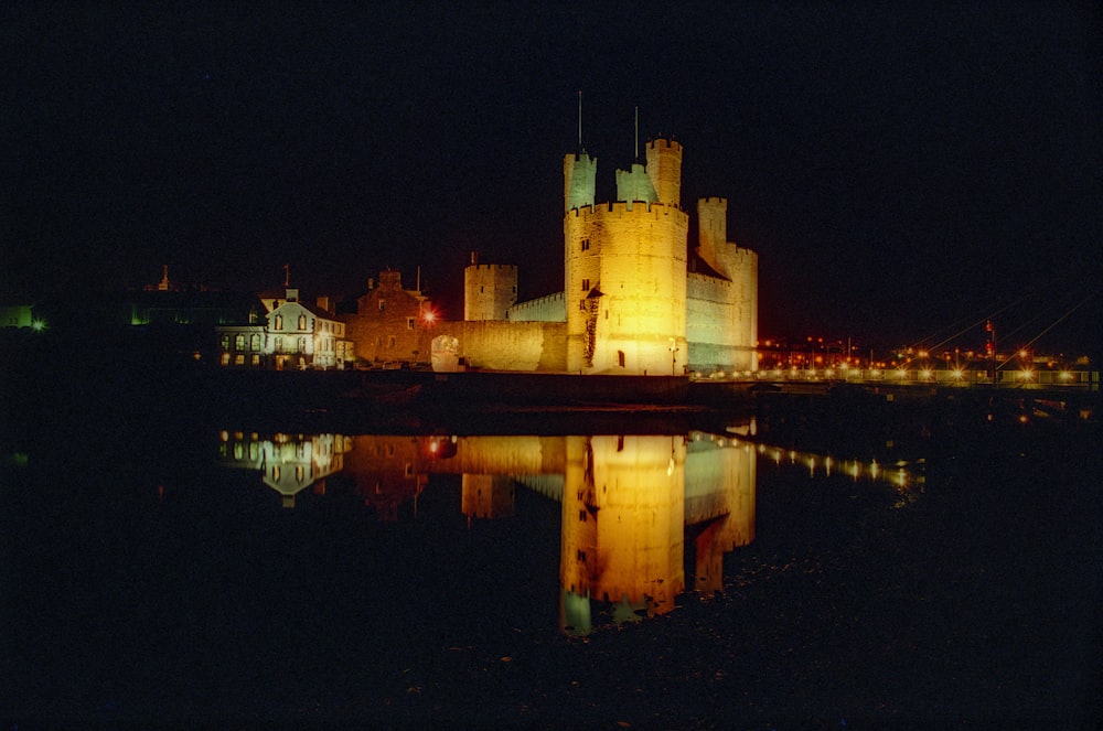 Eine nachts beleuchtete Burg mit einer Reflexion im Wasser