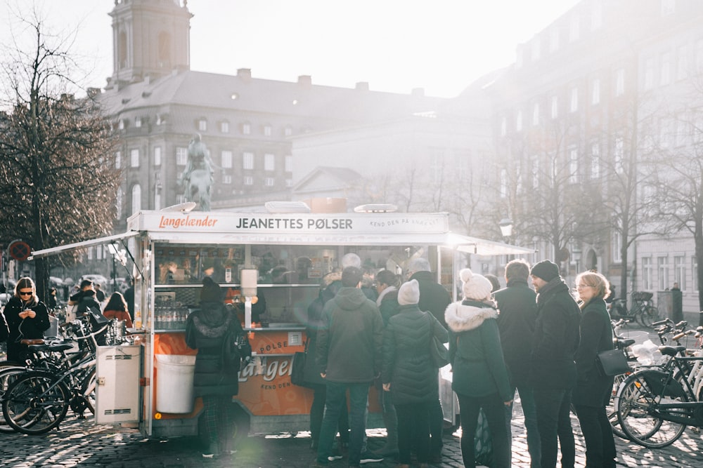 a group of people standing around a food truck