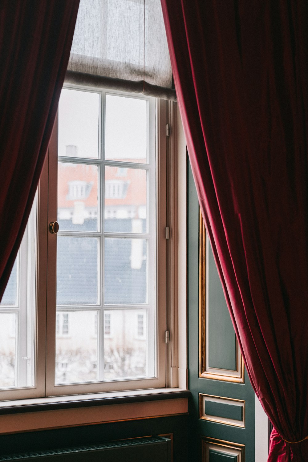 a window with a red curtain and a window sill
