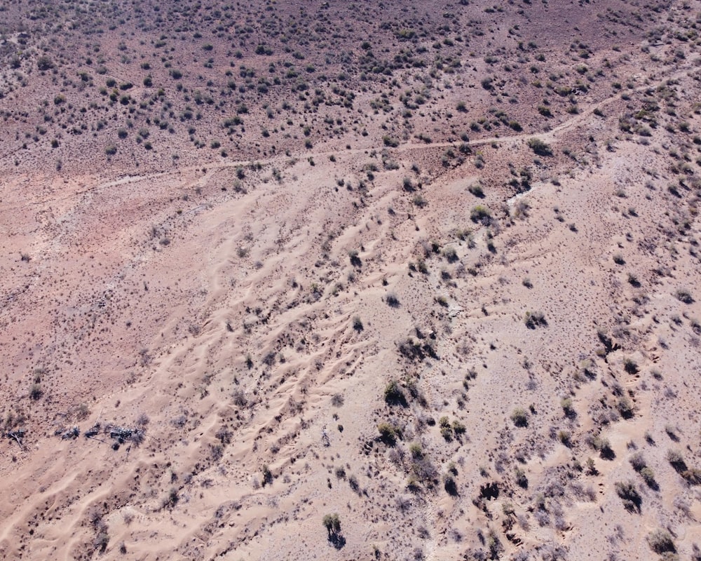 an aerial view of a dirt road in the middle of the desert