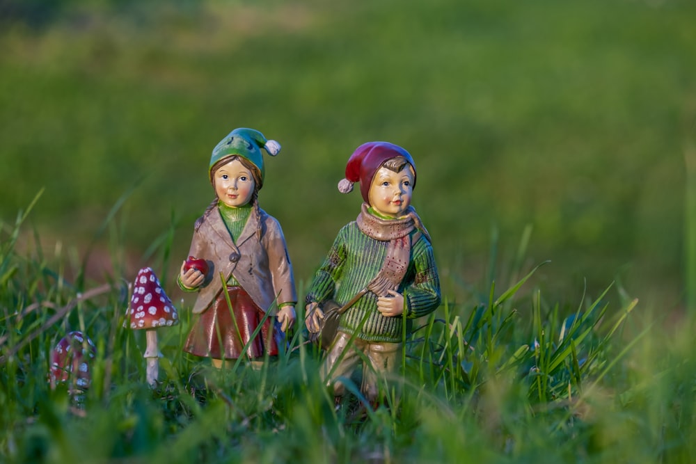 a couple of figurines that are standing in the grass