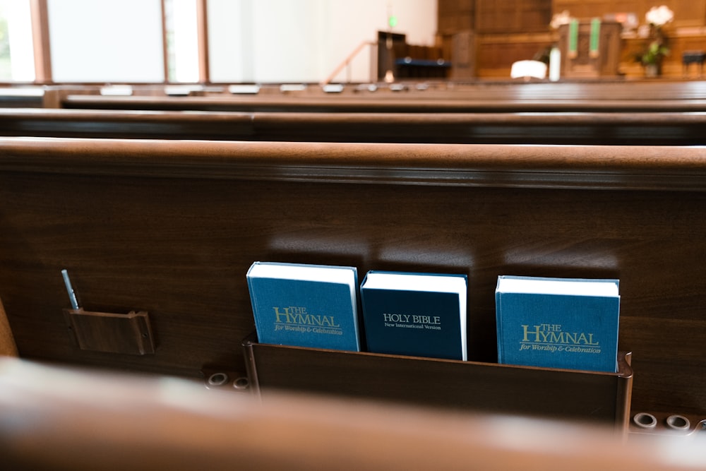 a couple of blue books sitting on top of a wooden table