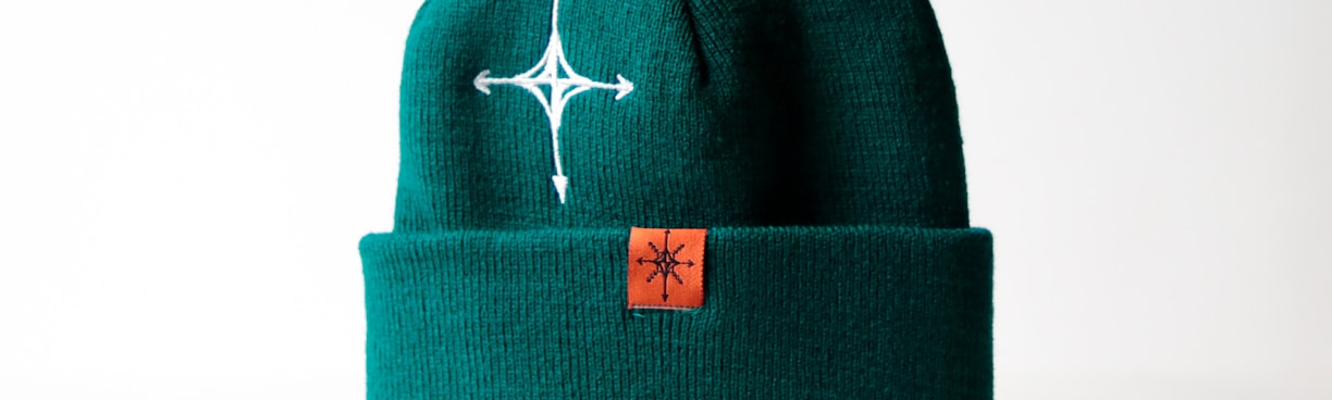 a green hat with a white cross on it