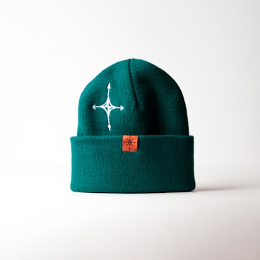 a green hat with a white cross on it