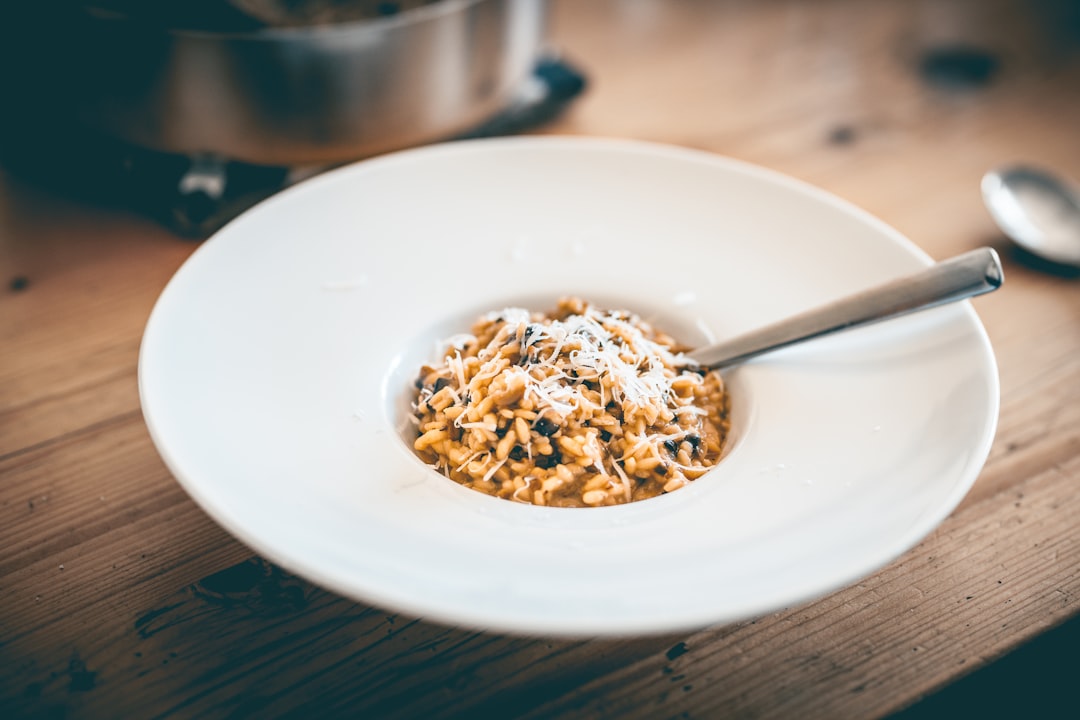 a bowl of food on a wooden table, mushroom risotto