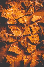 Close-up of golden jaggery cubes stacked neatly on a rustic wooden surface.
