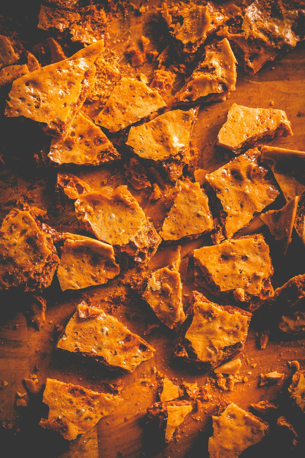 a pile of tortilla chips sitting on top of a wooden cutting board