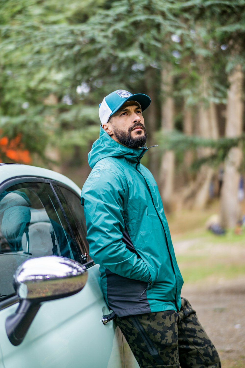 a man leaning on the side of a car