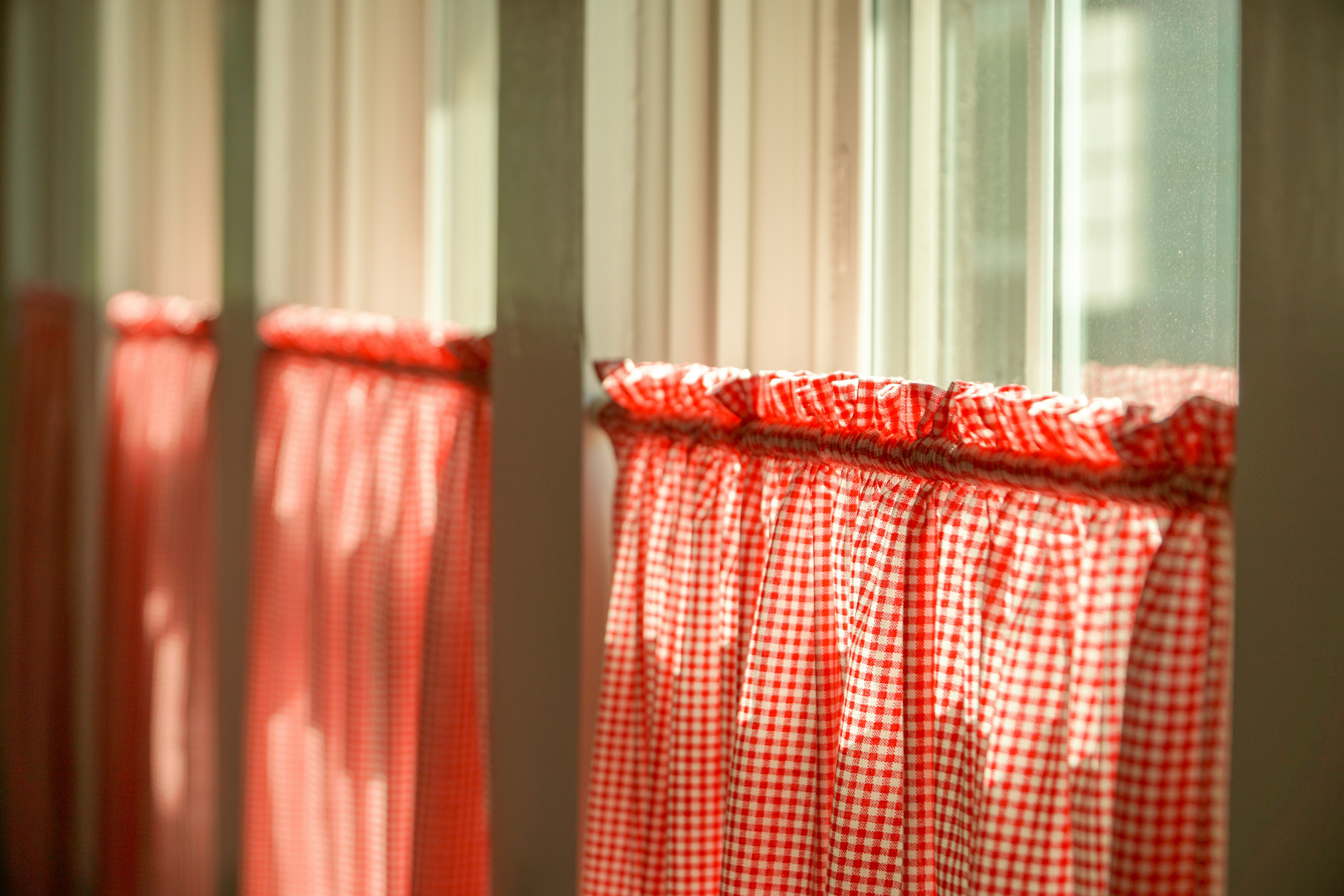 a red and white checkered curtain hanging in front of a window