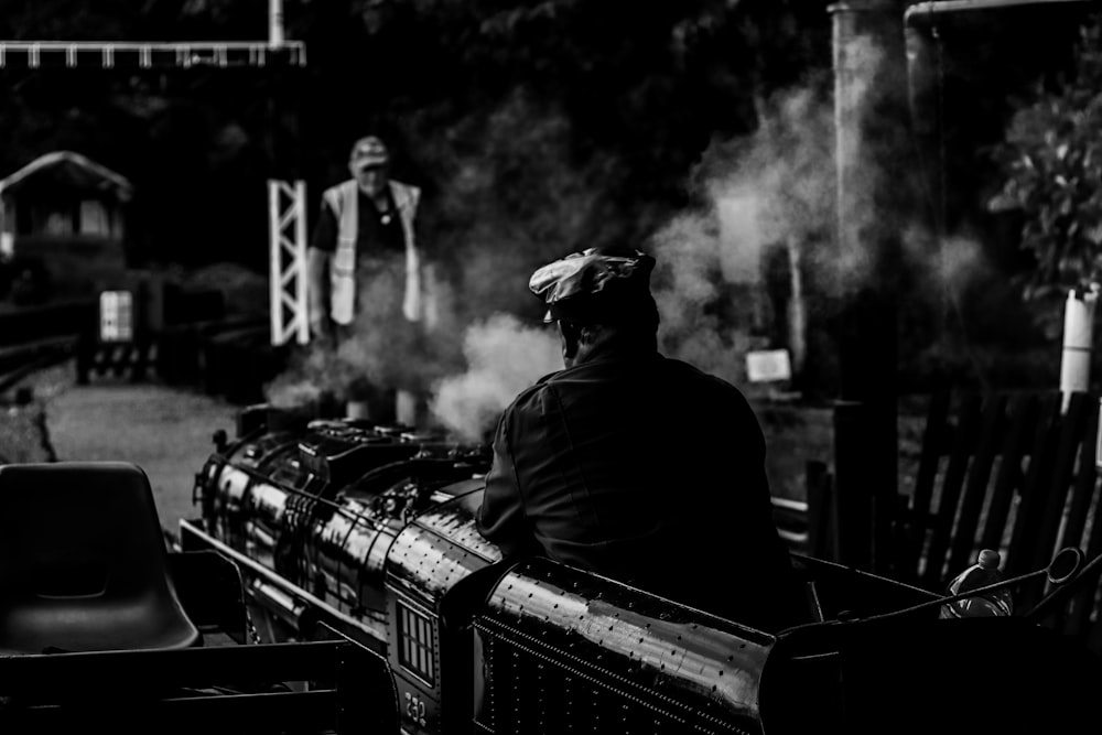 Una foto in bianco e nero di un uomo su un treno