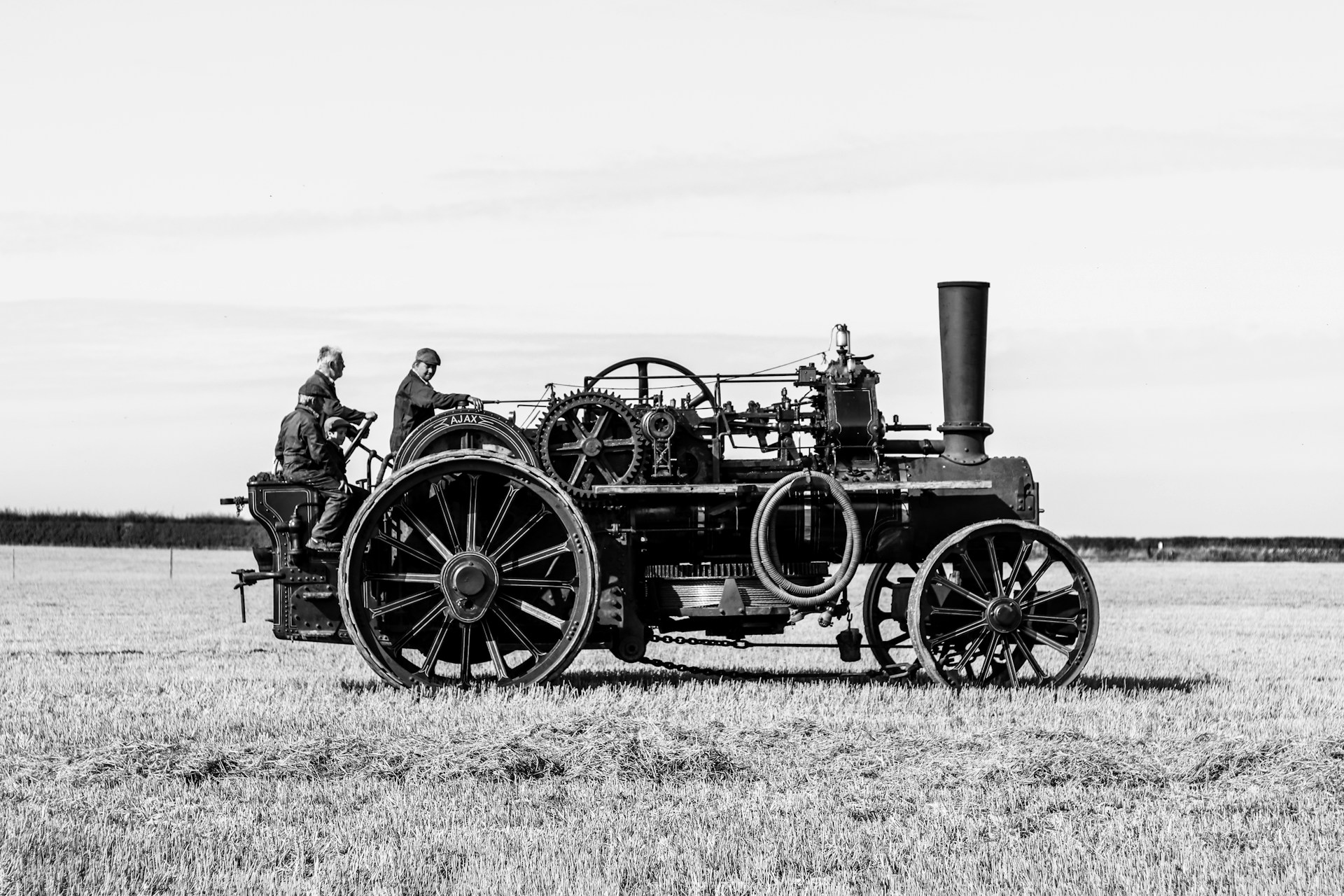 a black and white photo of a man driving a tractor