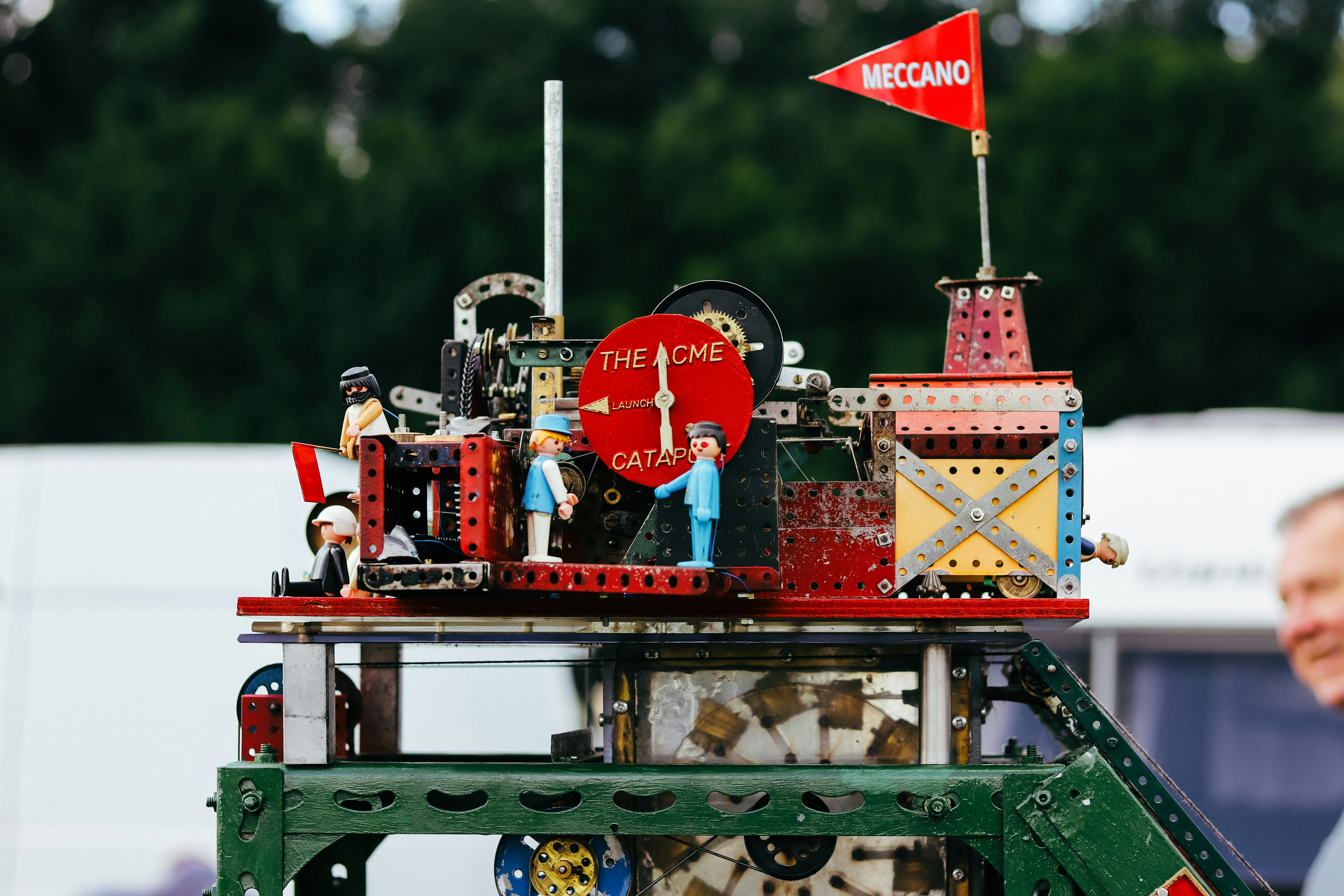 a man standing next to a model of a clock tower