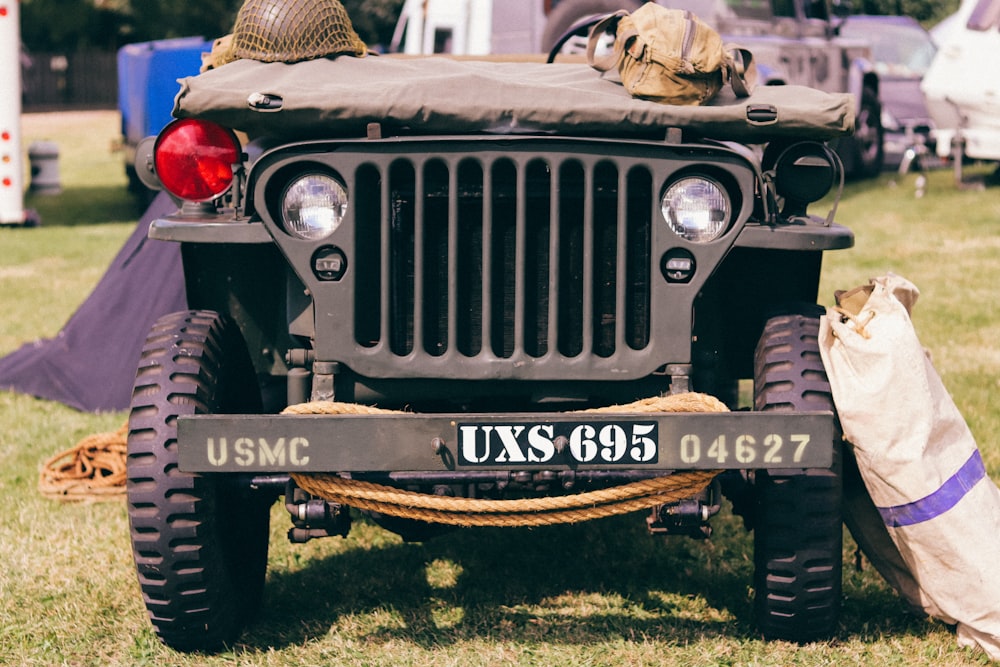 a military jeep parked in a grassy field