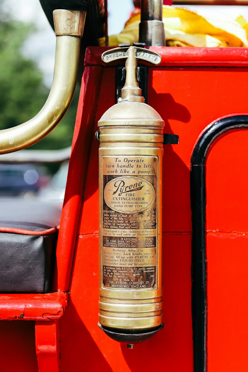 an old fashioned fire extinguisher sitting on a red truck