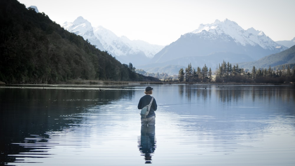 Un homme debout dans l’eau tenant un poisson