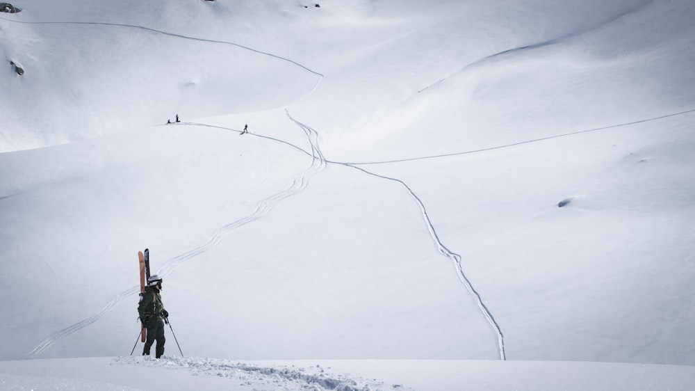 a person walking up a snowy hill with skis