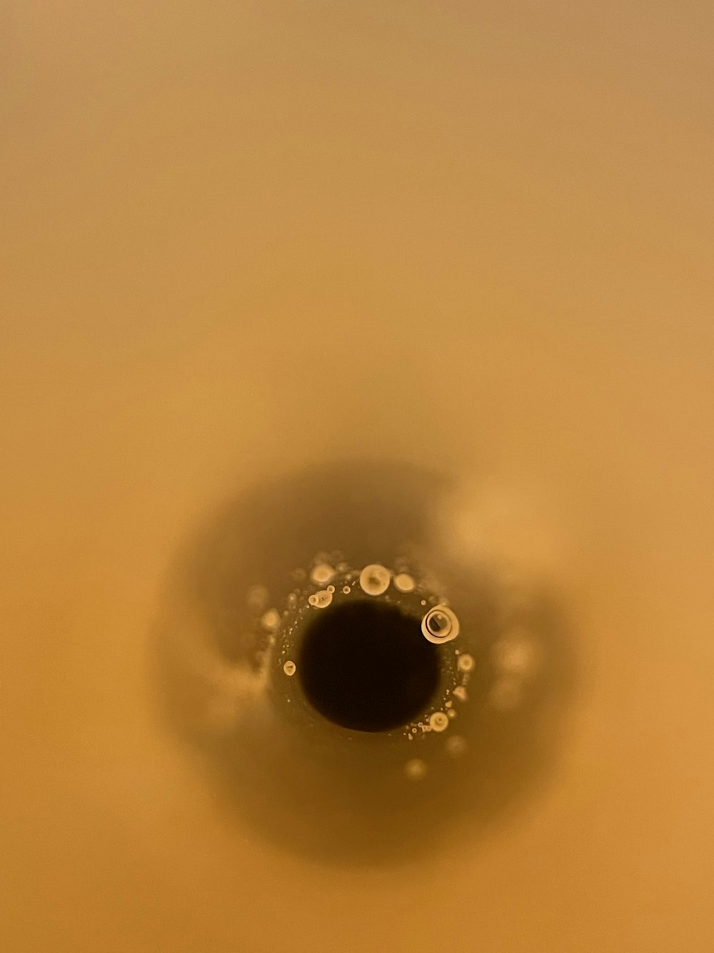 a black hole in the ground with water droplets