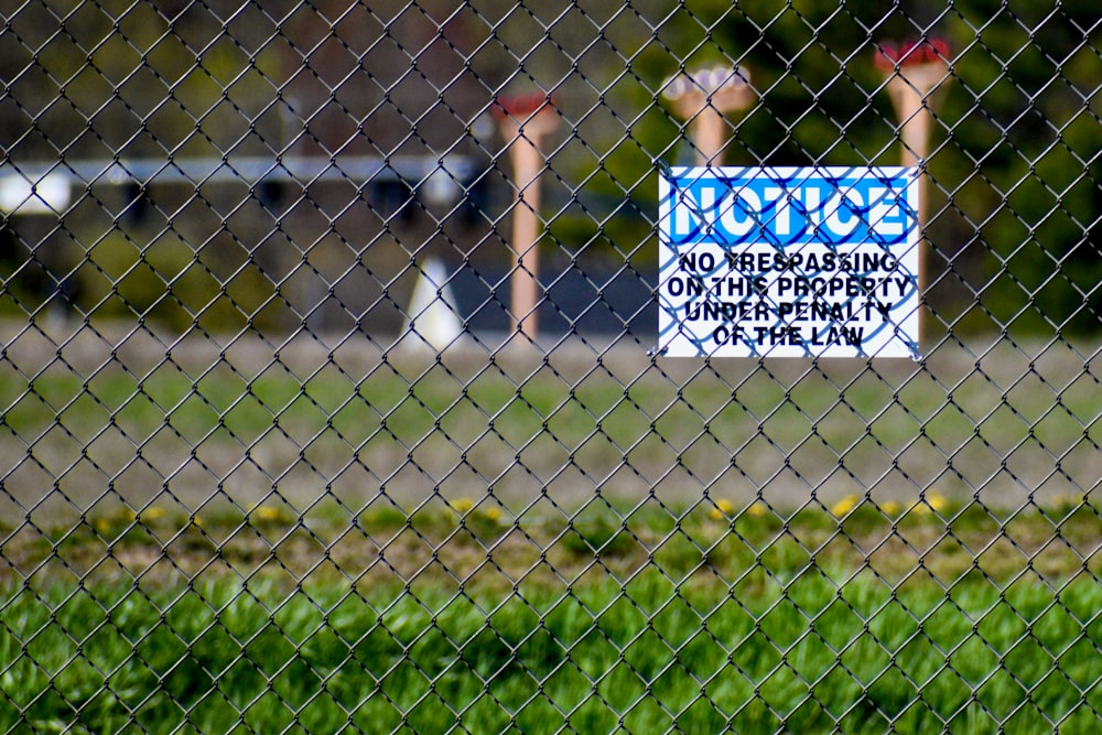 a sign on a chain link fence that reads notice no trespassing on the