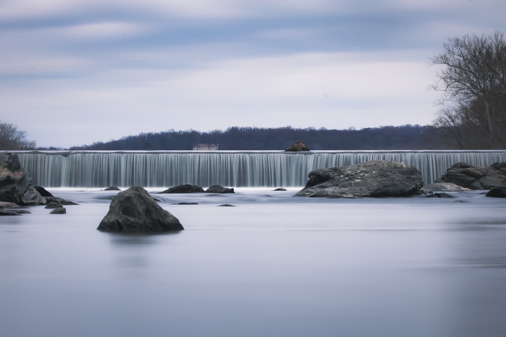 une photo longue exposition d’une rivière avec une cascade en arrière-plan