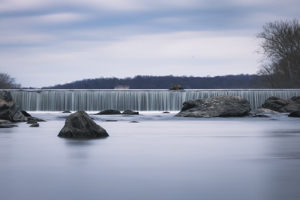 a long exposure photo of a river with a waterfall in the background