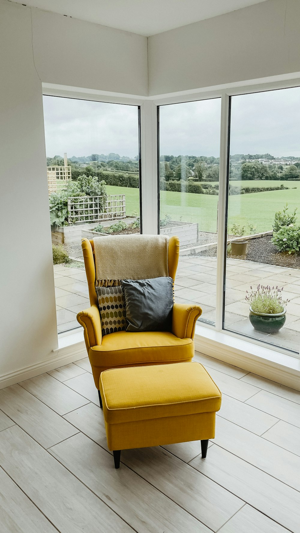 a living room with a yellow chair and ottoman