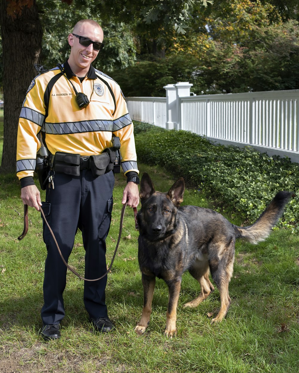 a police officer is walking his dog in the yard