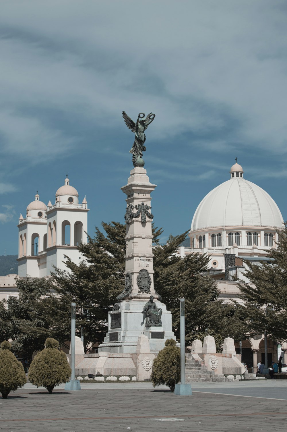 a statue in front of a building with a dome