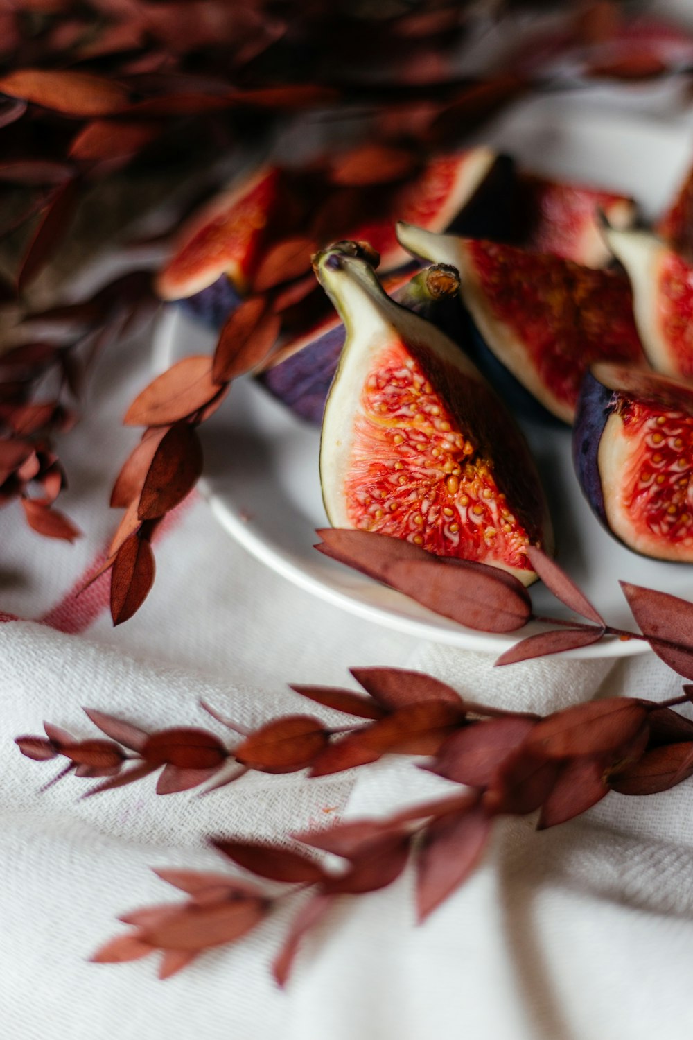 a plate of sliced figs and leaves on a table