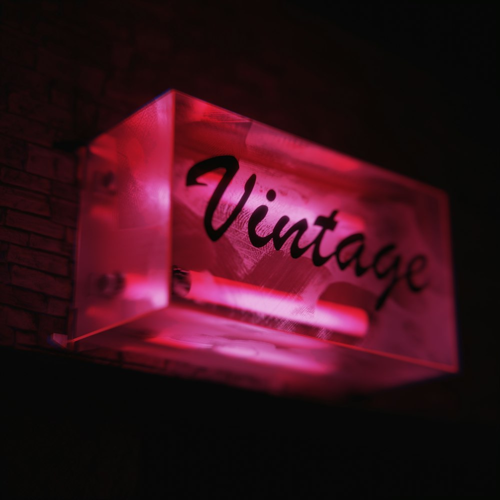 a lighted sign that reads vintage on a brick wall