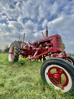 A classic tractor parked beside a field under a big Iowa sky.
