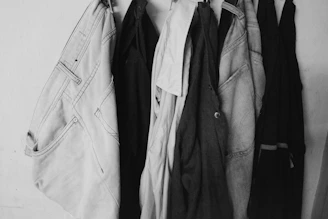 a black and white photo of clothes hanging on a rack