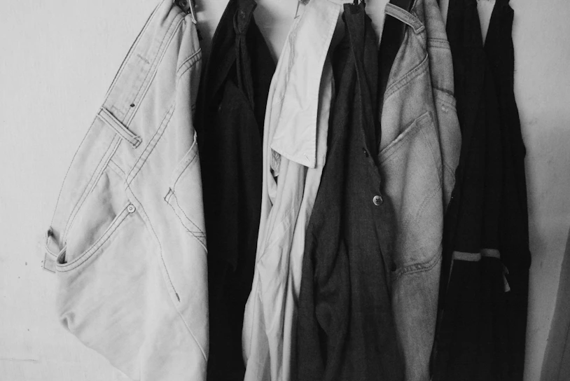 a black and white photo of clothes hanging on a rack