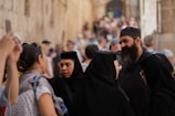 A diverse group of people wearing kippahs together in a peaceful outdoor setting.