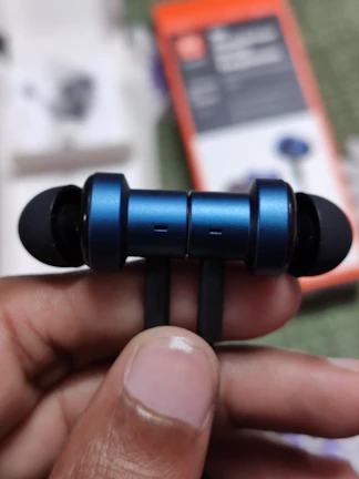 Close-up of hands unboxing a livlynx wireless earbud set with premium packaging.