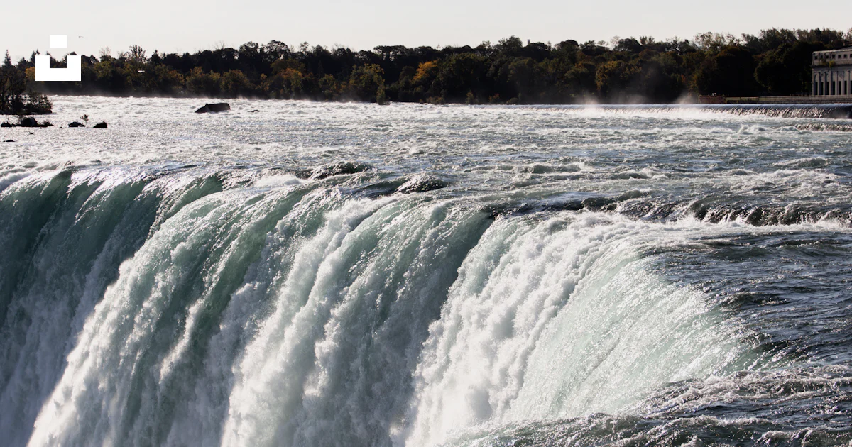 A large waterfall with water pouring out of it photo – Free Waterfall ...